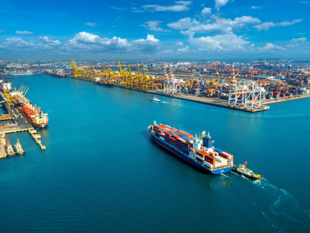 Aerial view of cargo ship and cargo container in harbor.